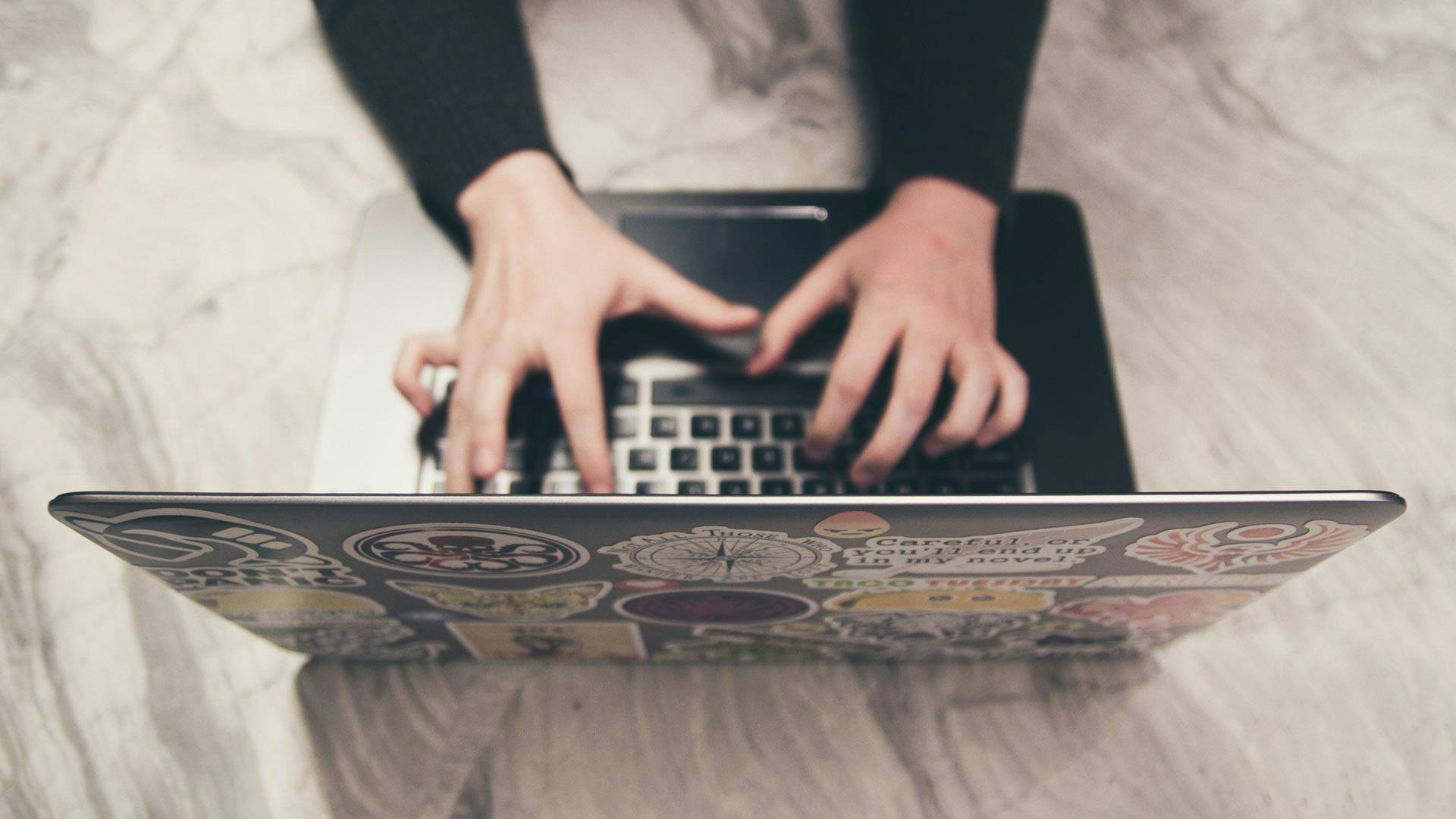 man typing on computer on desk
